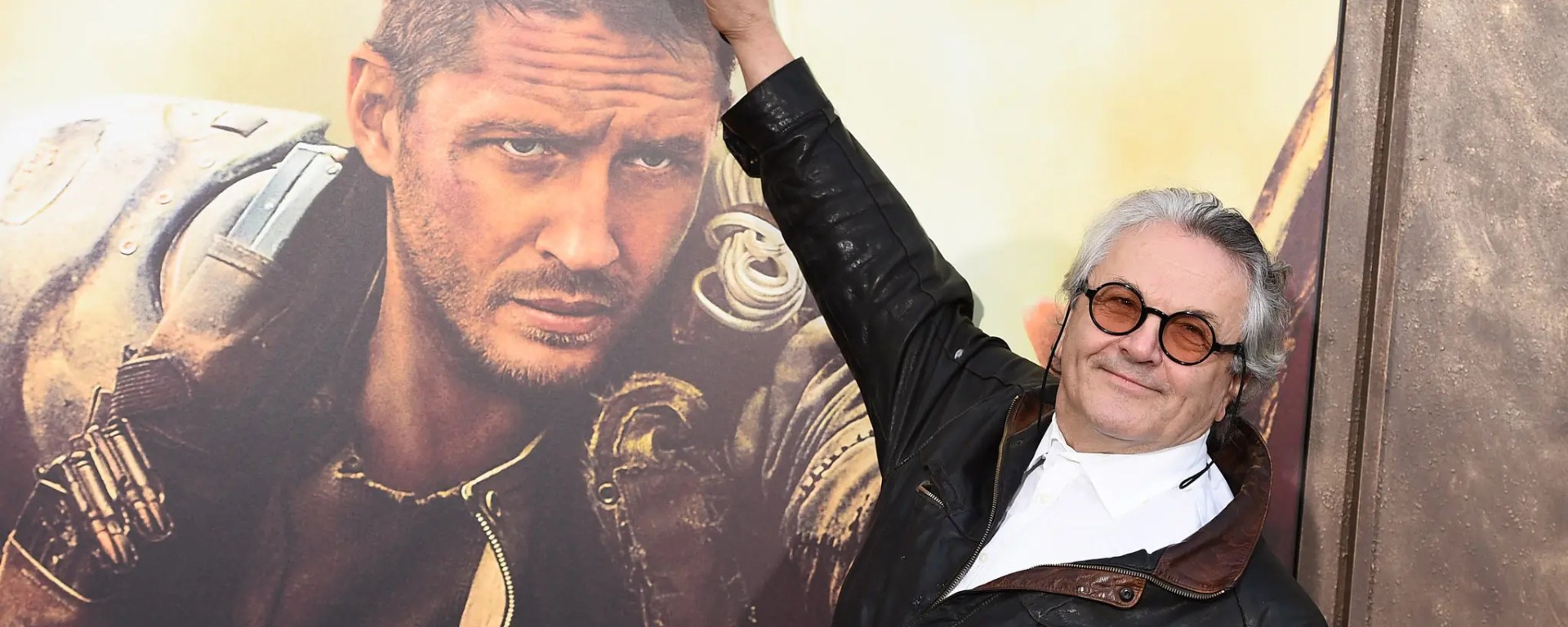 George Miller with Mad Max: Fury Road poster